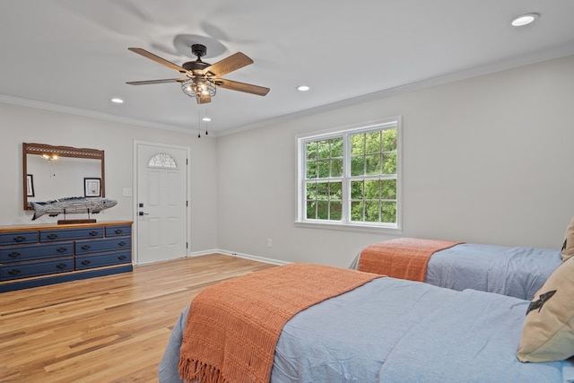 bedroom featuring ceiling fan, crown molding, and light hardwood / wood-style floors