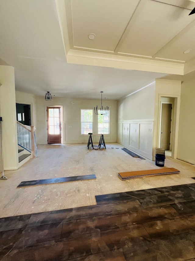 280 Greystone Dr, Milledgeville, GA 31061 - unfurnished living room with stairs, a chandelier, a wainscoted wall, and a decorative wall