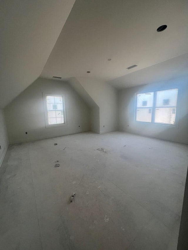 additional living space featuring vaulted ceiling and visible vents