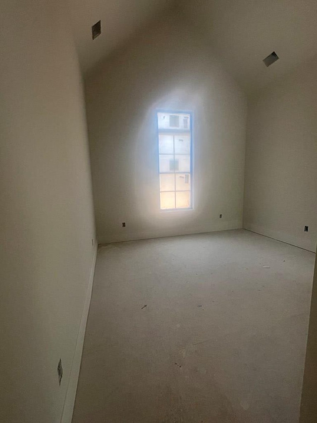 spare room with lofted ceiling and visible vents