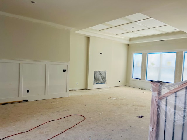 unfurnished room with a wainscoted wall, crown molding, coffered ceiling, and a decorative wall