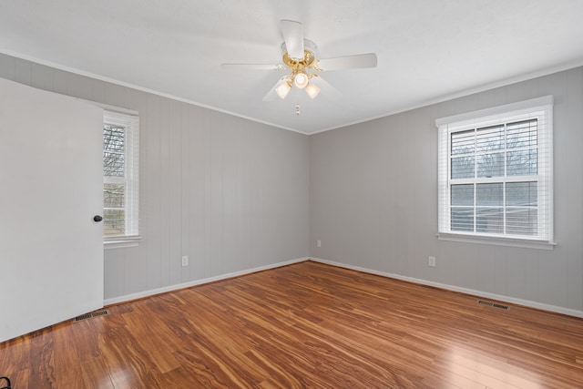 110 Westminster Dr, Eatonton, GA 31024 - empty room featuring ornamental molding, visible vents, a ceiling fan, and wood finished floors