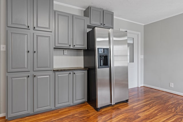 110 Westminster Dr, Eatonton, GA 31024 - kitchen with stainless steel fridge, crown molding, baseboards, gray cabinetry, and dark wood-style floors