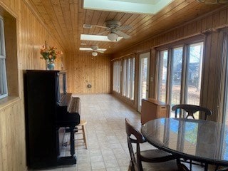 dining area featuring wood ceiling, ceiling fan, and wooden walls