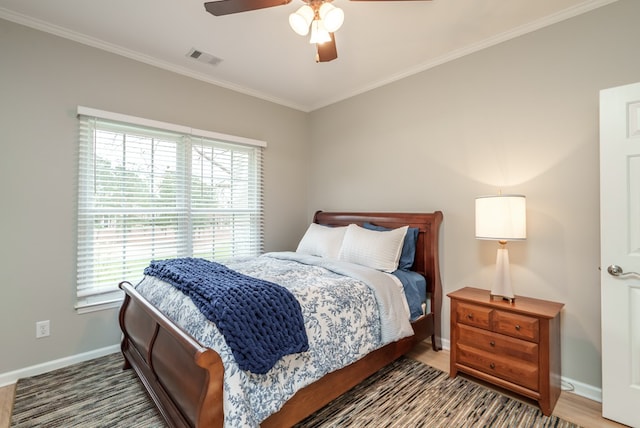 bedroom with hardwood / wood-style floors, ceiling fan, crown molding, and multiple windows