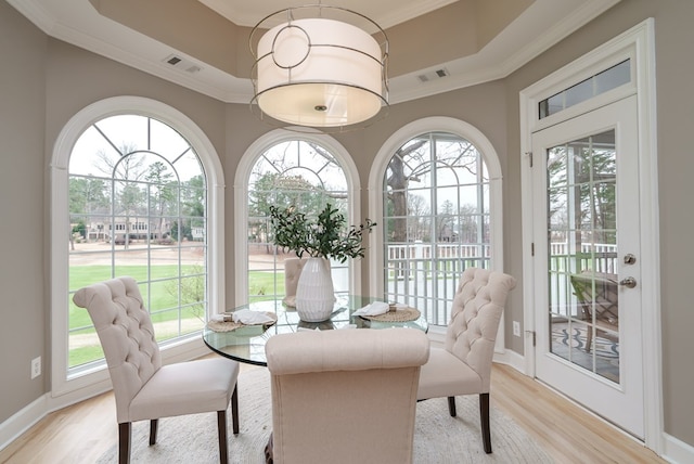 dining room with crown molding and light hardwood / wood-style flooring