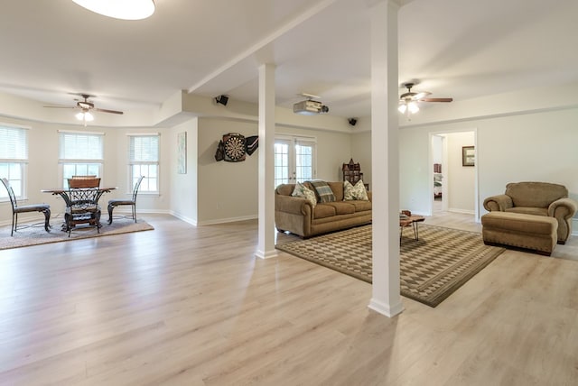 living room featuring light hardwood / wood-style flooring, ceiling fan, and a healthy amount of sunlight