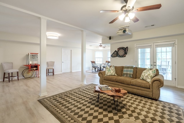 living room featuring ceiling fan, light hardwood / wood-style floors, plenty of natural light, and french doors