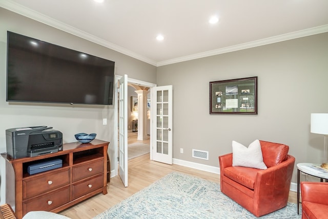 living area featuring french doors, light hardwood / wood-style floors, and ornamental molding