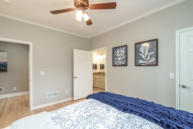 bedroom featuring light wood-type flooring, ensuite bathroom, ceiling fan, and crown molding