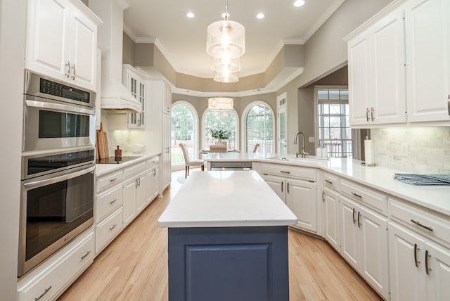 kitchen featuring white cabinets, appliances with stainless steel finishes, a kitchen island, and sink