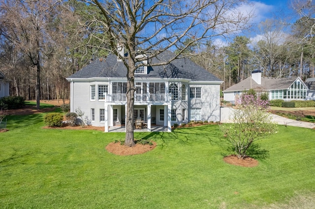 rear view of house featuring a lawn, a sunroom, a patio, and a wooden deck