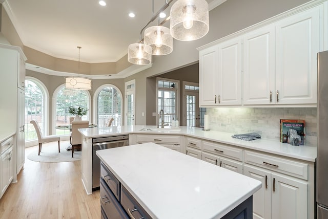 kitchen featuring white cabinets, pendant lighting, a kitchen island, and sink