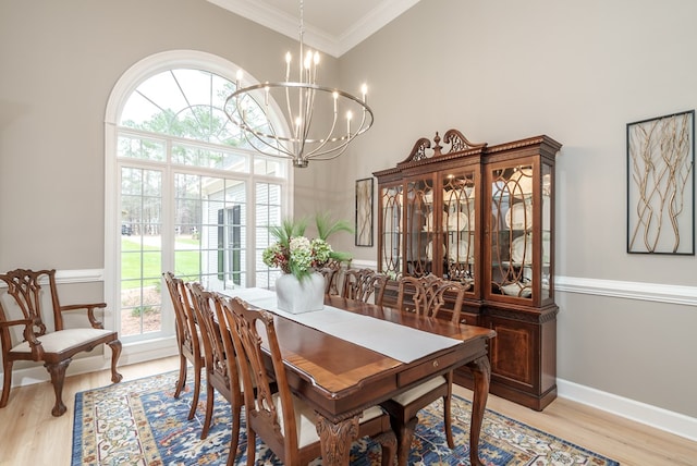 dining room featuring light hardwood / wood-style floors, crown molding, and an inviting chandelier