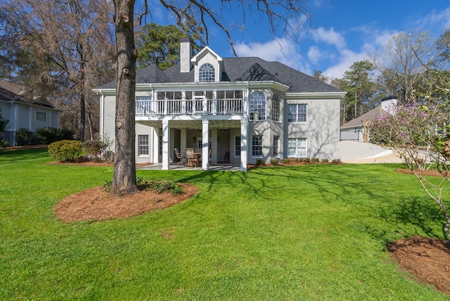 rear view of property featuring a lawn, a patio, and a wooden deck