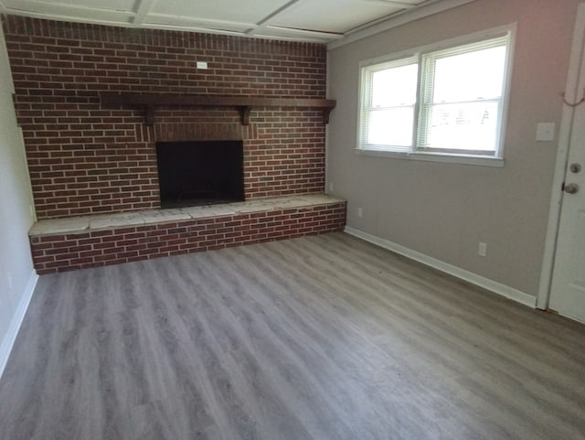 unfurnished living room with light hardwood / wood-style floors and a brick fireplace