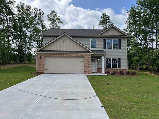 461 Riley Cir, Milledgeville, GA 31061 - view of front of property with brick siding, concrete driveway, a front lawn, and a garage