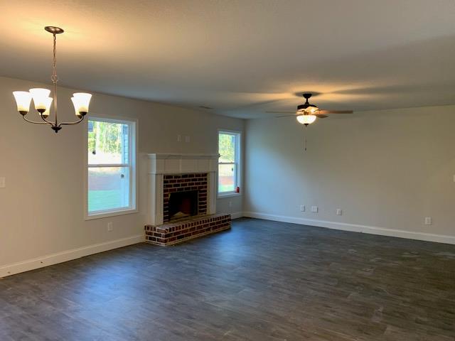 461 Riley Cir, Milledgeville, GA 31061 - unfurnished living room featuring dark wood-type flooring, healthy amount of natural light, a chandelier, and a ceiling fan
