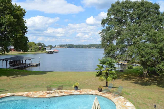 view of swimming pool with a boat dock, a water view, and a yard