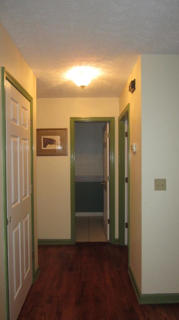 131 NE Carriage Ct, Milledgeville, GA 31061 - hall with a textured ceiling, wood finished floors, and baseboards