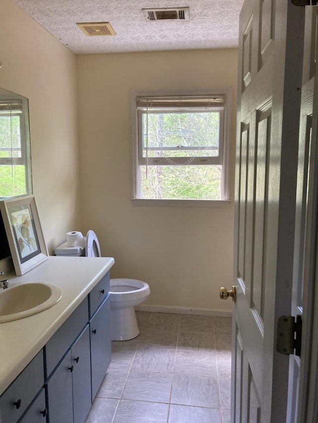 131 NE Carriage Ct, Milledgeville, GA 31061 - bathroom with vanity, visible vents, a textured ceiling, and toilet