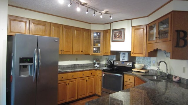 131 NE Carriage Ct, Milledgeville, GA 31061 - kitchen with ornamental molding, brown cabinetry, dark stone counters, appliances with stainless steel finishes, and a sink