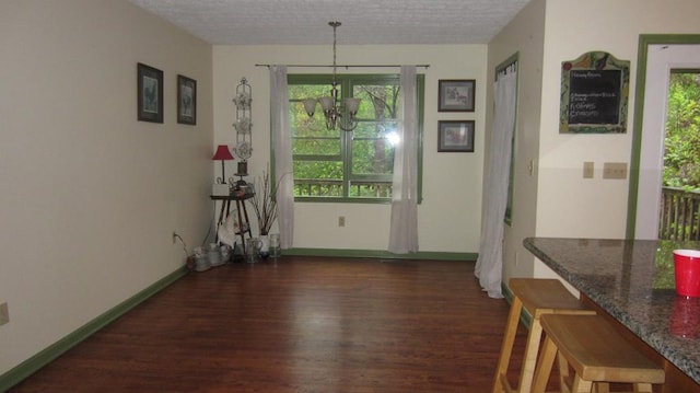 131 NE Carriage Ct, Milledgeville, GA 31061 - dining area featuring a textured ceiling, wood finished floors, an inviting chandelier, and baseboards