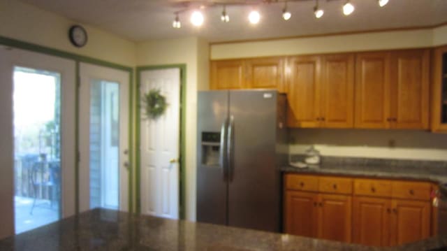 131 NE Carriage Ct, Milledgeville, GA 31061 - kitchen with dark stone countertops, brown cabinets, and stainless steel refrigerator with ice dispenser