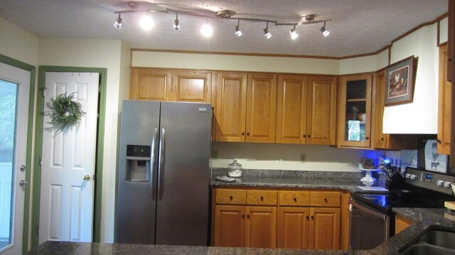 131 NE Carriage Ct, Milledgeville, GA 31061 - kitchen featuring glass insert cabinets, a textured ceiling, brown cabinetry, dark stone counters, and appliances with stainless steel finishes