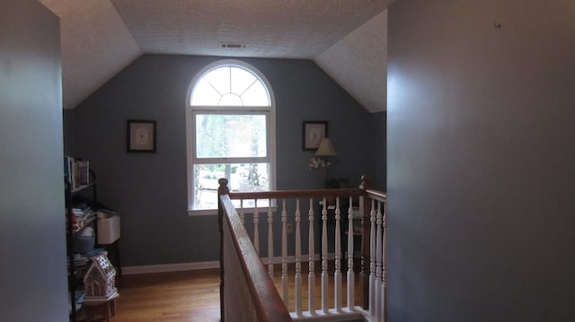 131 NE Carriage Ct, Milledgeville, GA 31061 - stairway featuring a textured ceiling, vaulted ceiling, visible vents, wood finished floors, and baseboards