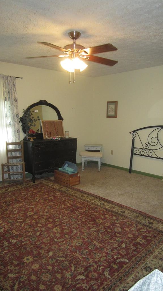 131 NE Carriage Ct, Milledgeville, GA 31061 - bedroom with baseboards, ceiling fan, carpet, and a textured ceiling