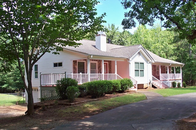 121 Long Island Dr, Eatonton, GA 31024 - ranch-style home with covered porch, a chimney, a shingled roof, a garage, and driveway