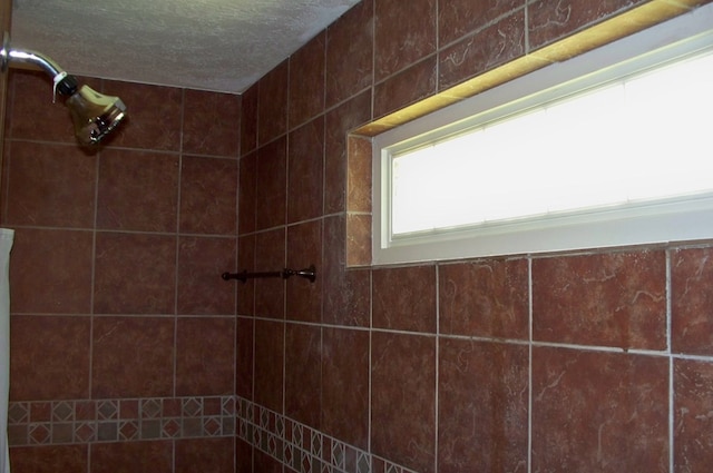 121 Long Island Dr, Eatonton, GA 31024 - bathroom with a tile shower and a textured ceiling