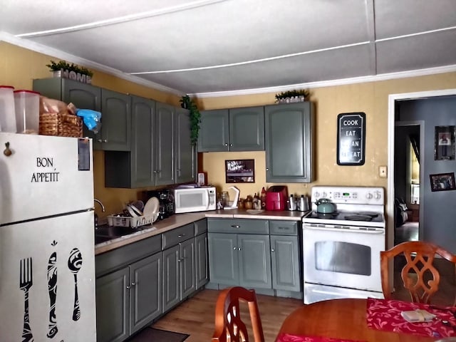 kitchen with hardwood / wood-style floors, white appliances, and gray cabinets