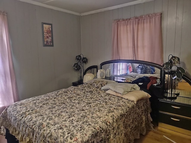 bedroom featuring hardwood / wood-style flooring, crown molding, and wooden walls