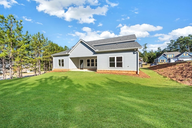 back of property with a yard and a patio