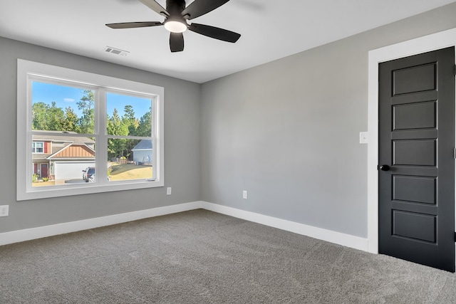 carpeted spare room with ceiling fan