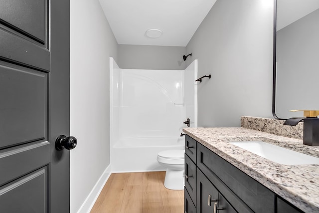 full bathroom featuring bathing tub / shower combination, hardwood / wood-style floors, vanity, and toilet