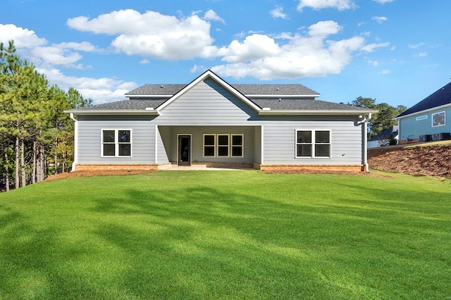 back of property with a yard and a patio