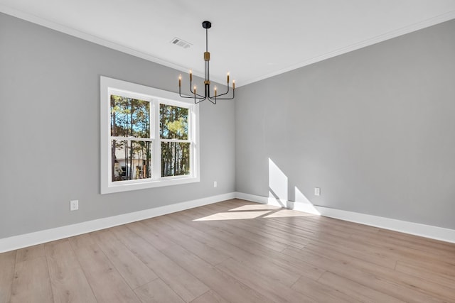 unfurnished room featuring light wood-type flooring, ornamental molding, and a chandelier