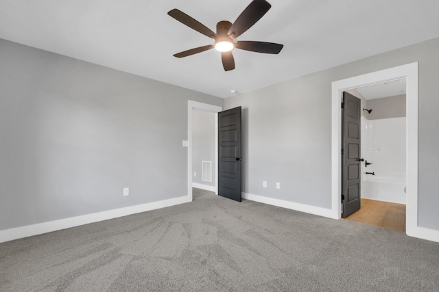 unfurnished bedroom with connected bathroom, light colored carpet, and ceiling fan