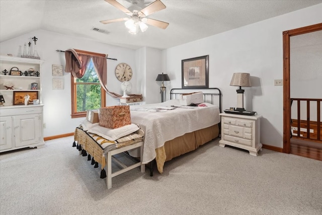 bedroom with baseboards, visible vents, lofted ceiling, and light colored carpet
