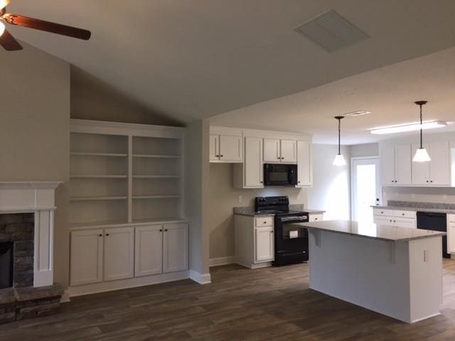 kitchen featuring black appliances, a kitchen island, dark wood-style floors, white cabinets, and a fireplace