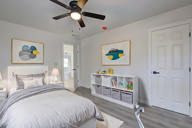 bedroom with baseboards, a ceiling fan, and wood finished floors