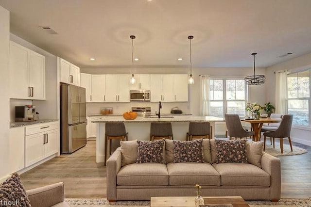 living area with recessed lighting and light wood-style flooring