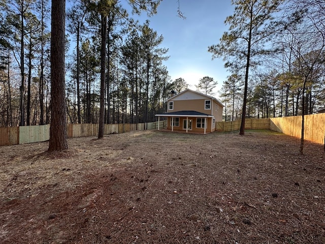 view of yard with a porch and a fenced backyard