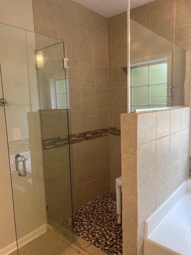 bathroom featuring plus walk in shower, a textured ceiling, and tile patterned floors