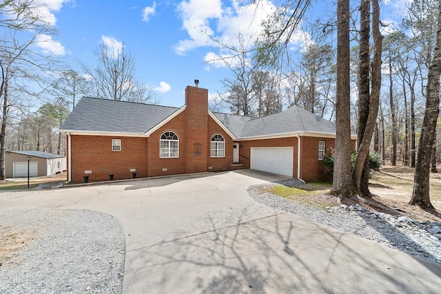 exterior space featuring a garage, brick siding, concrete driveway, and a chimney