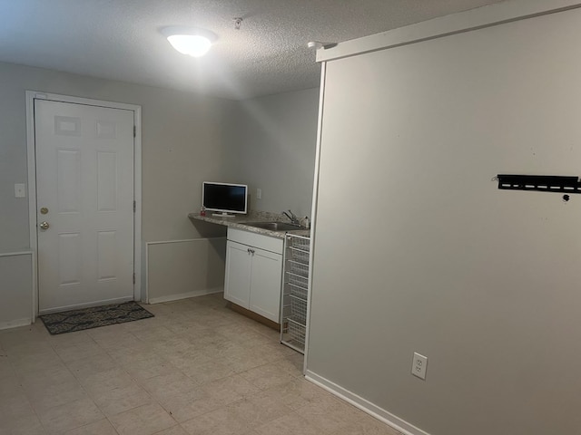 clothes washing area featuring sink and a textured ceiling