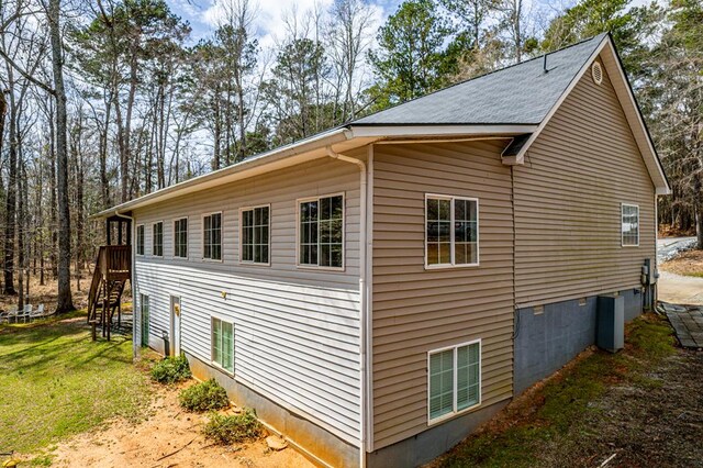 rear view of house with a yard, a deck, and central AC unit